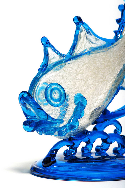 Poisson en verre de Murano côté tête, avec les yeux et les écailles émaillés de bleu, et posé sur un socle bleu