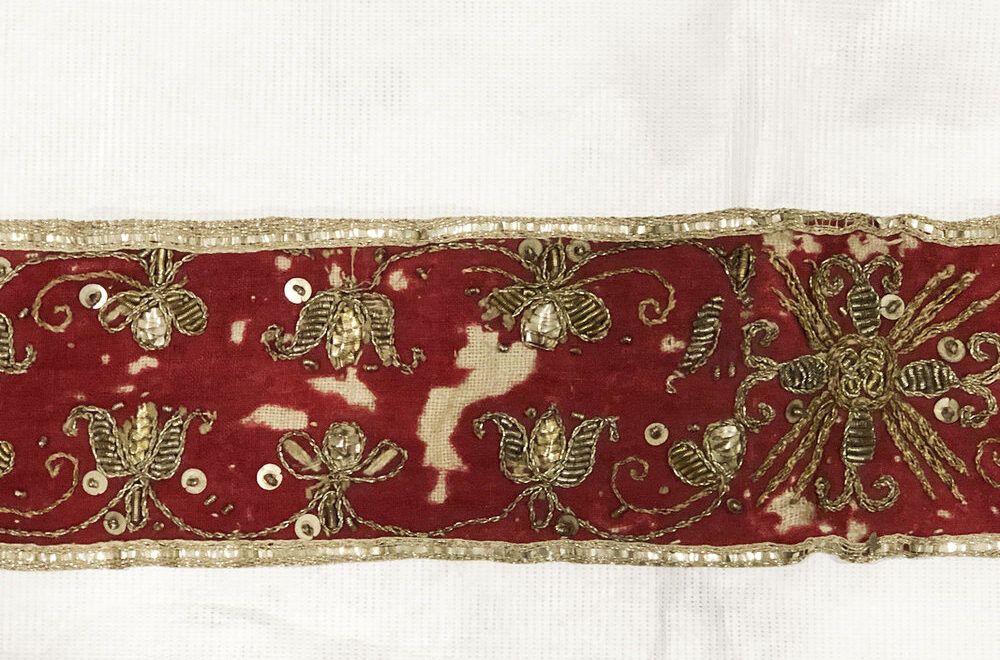 Ceinture de chasuble ancienne vue de près, avec ses broderies dorées sur fond rouge