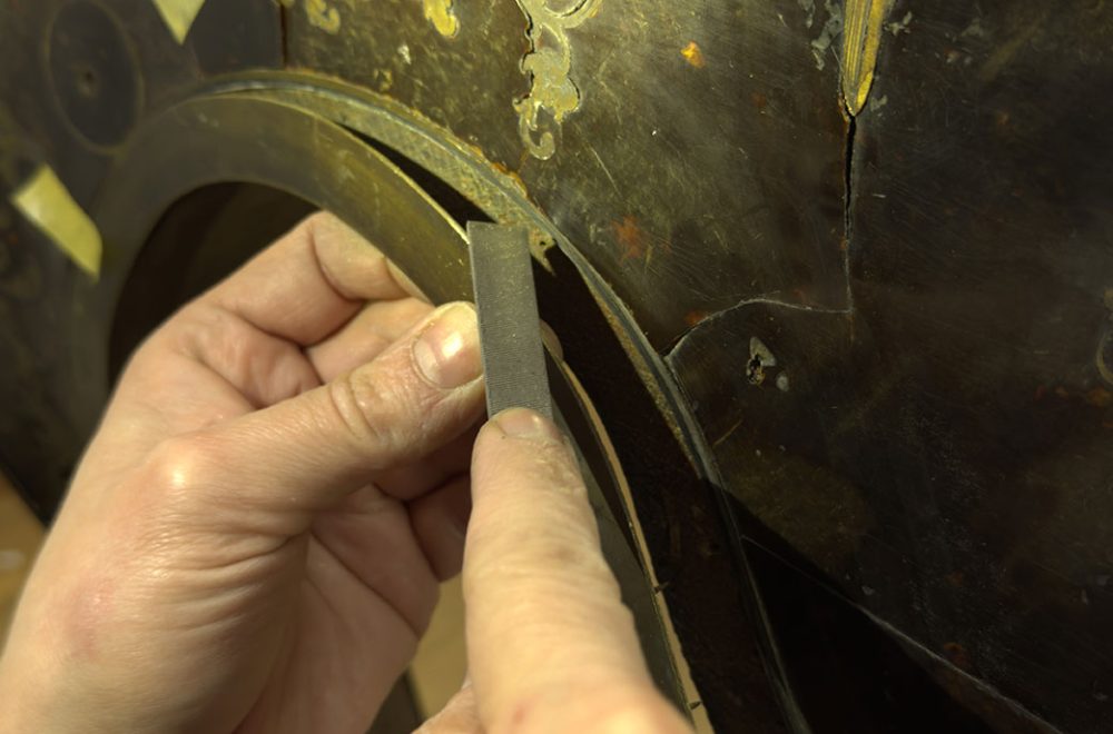 Mains ajustant un filet du bureau à la lime