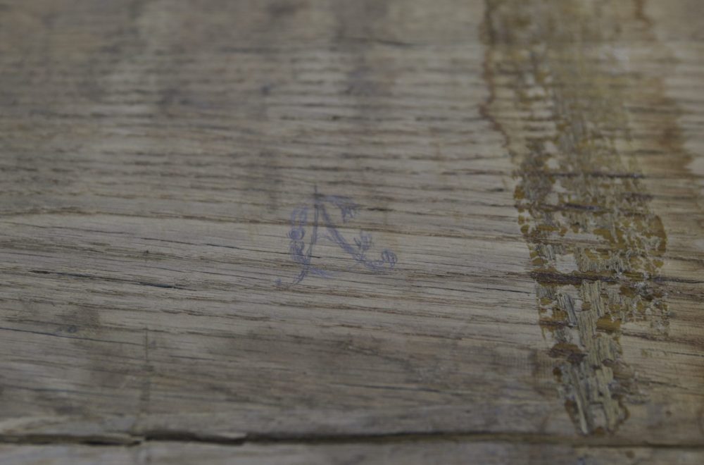 Bois du bureau en restauration, vu de près, avec la maqrue "AC"