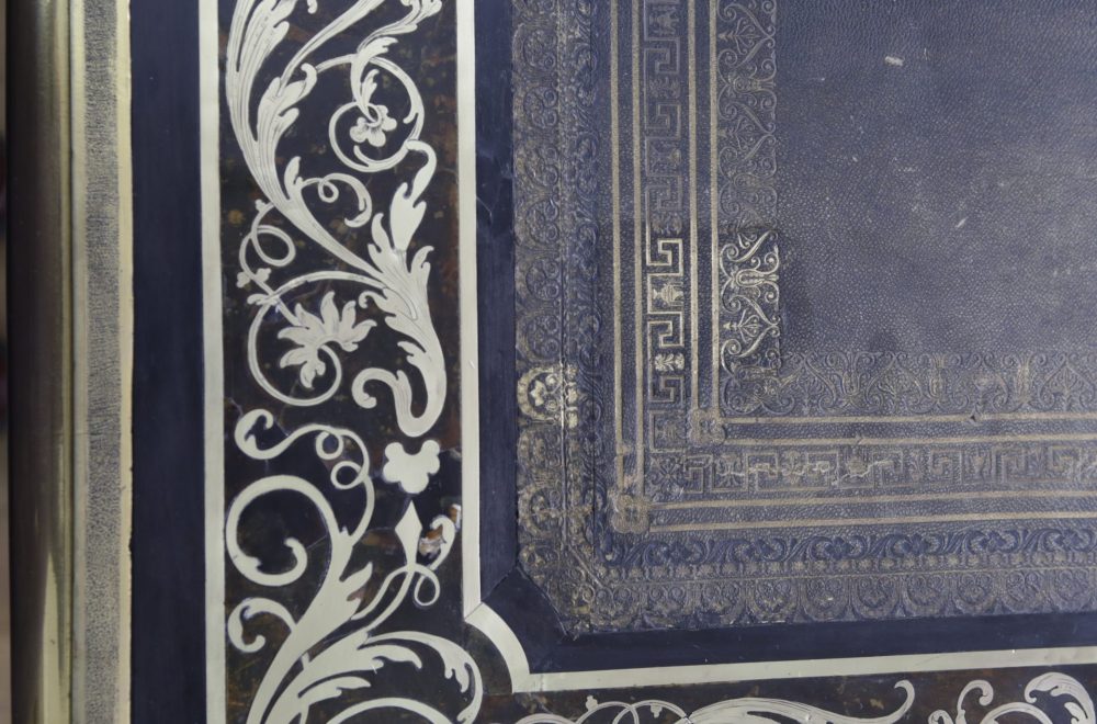 Travail sur le cuir et dorure en cours de traitement vus de près