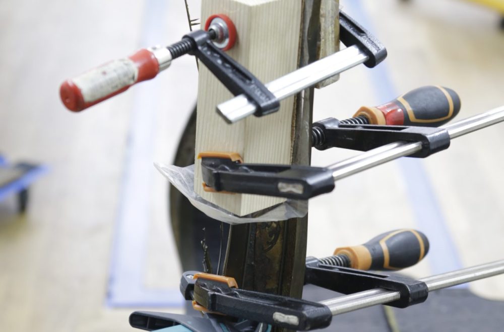 Recollage d'un pied du bureau en marqueterie, vue du travail d'atelier